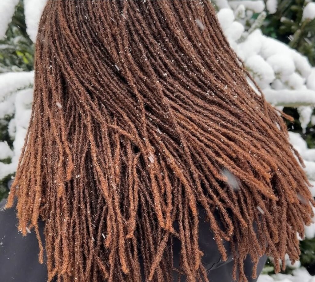 Backview of a woman on locs, out during winter