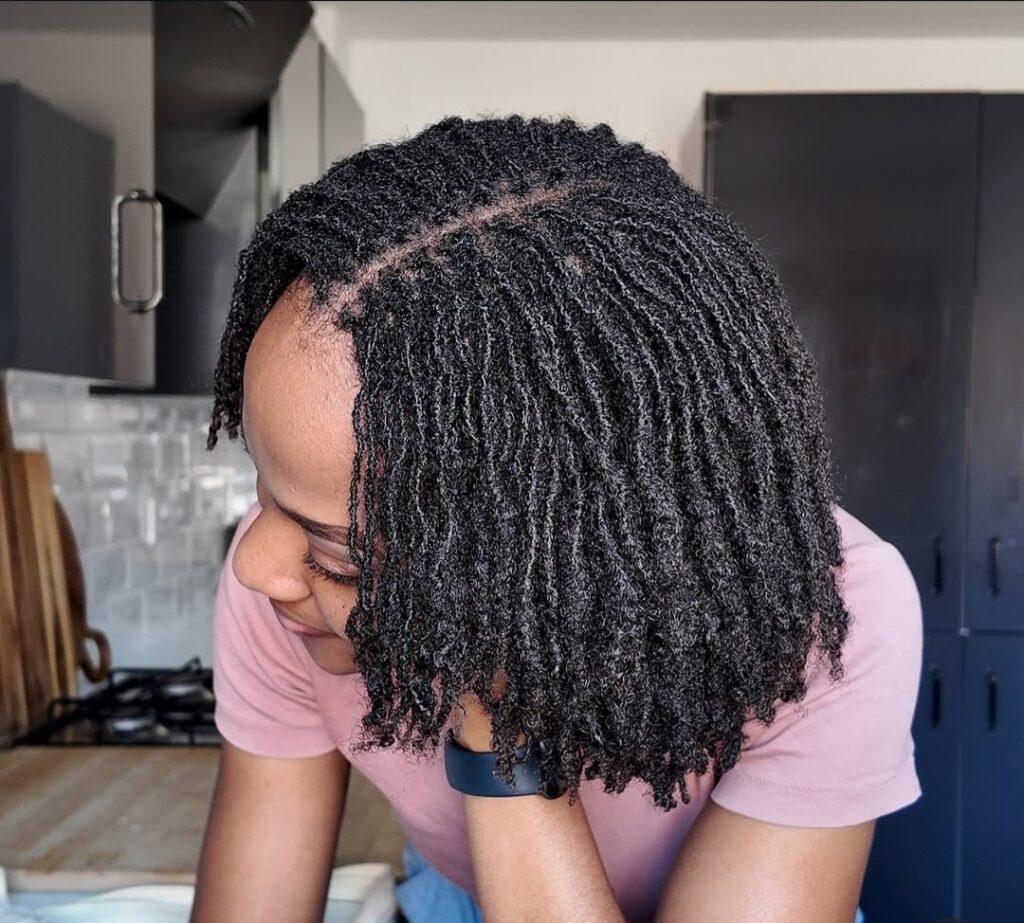 Back view of shoulder-length locs showing uniform size, mature texture, and natural curl pattern.