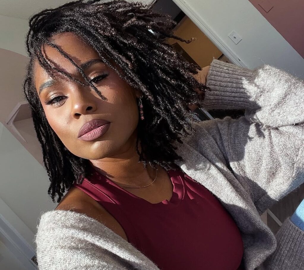 Selfie of a woman with shoulder-length locs.