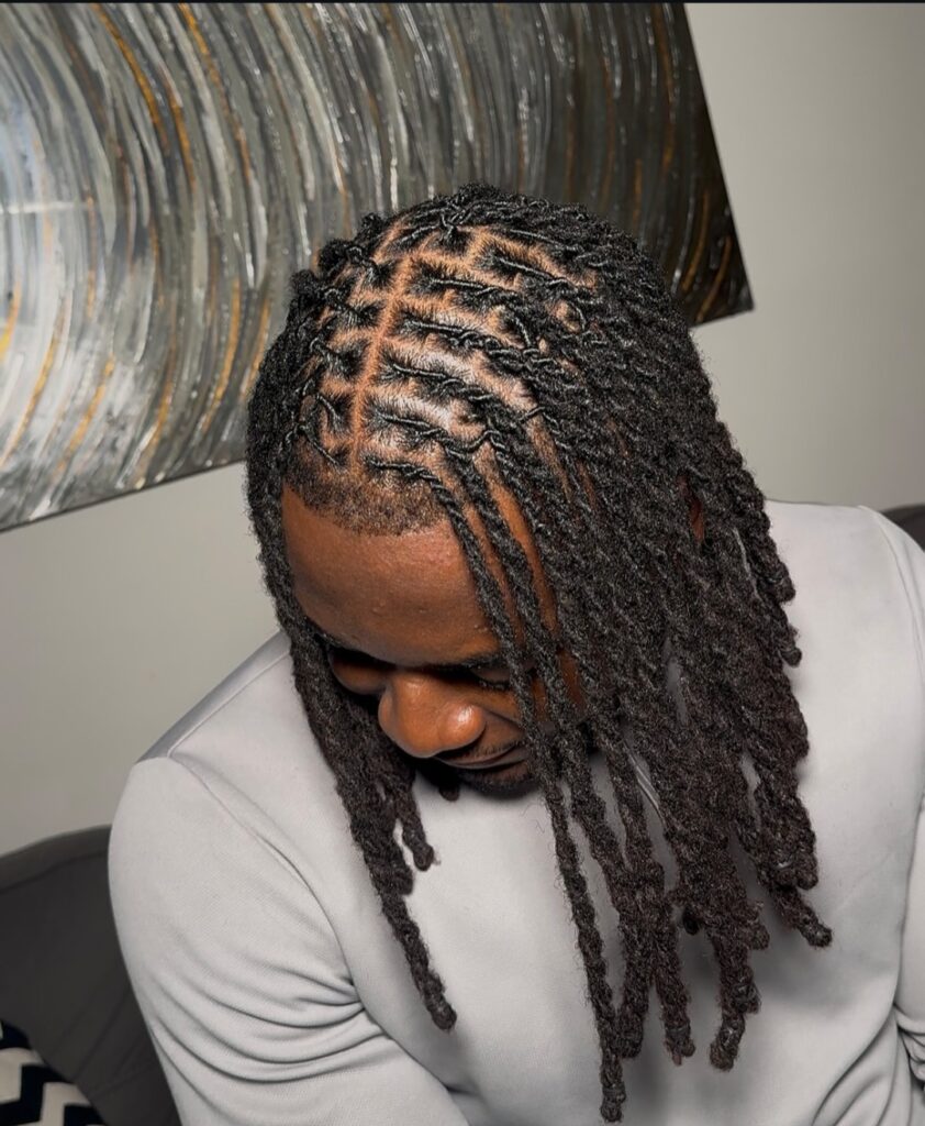 A man on center parted locs
