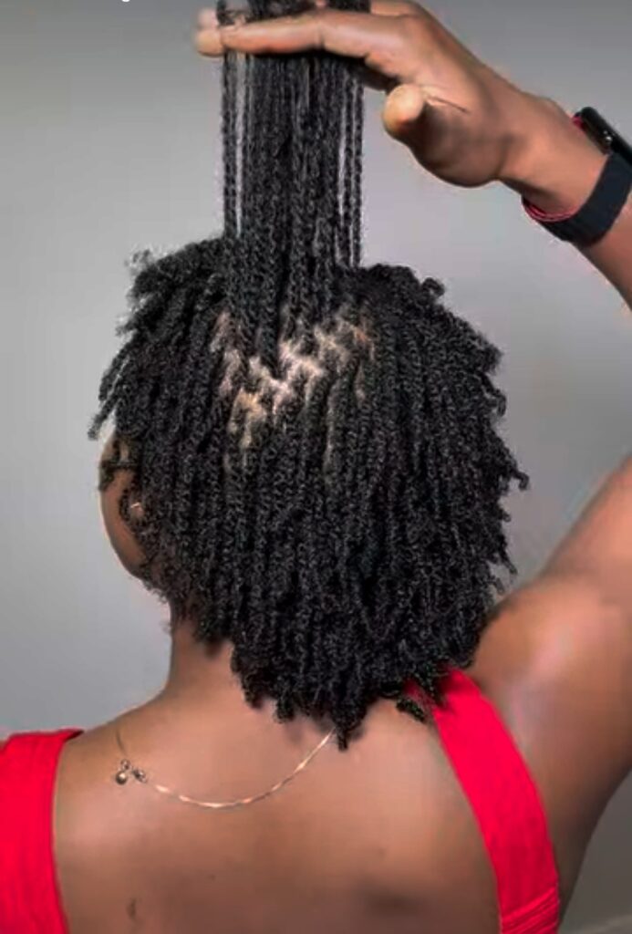 Hand lifting a section of locs