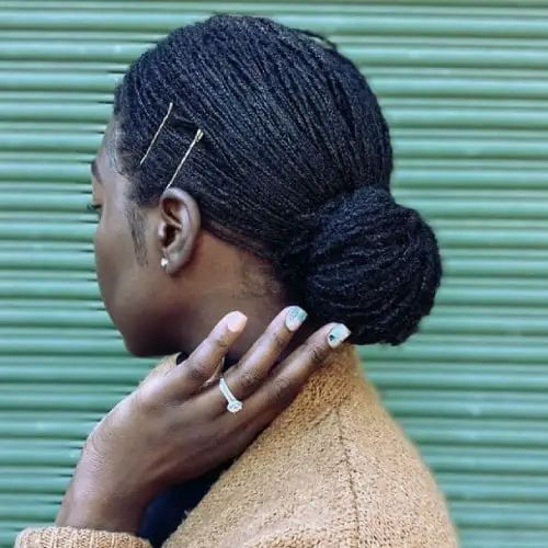 woman on low bun microlocs style