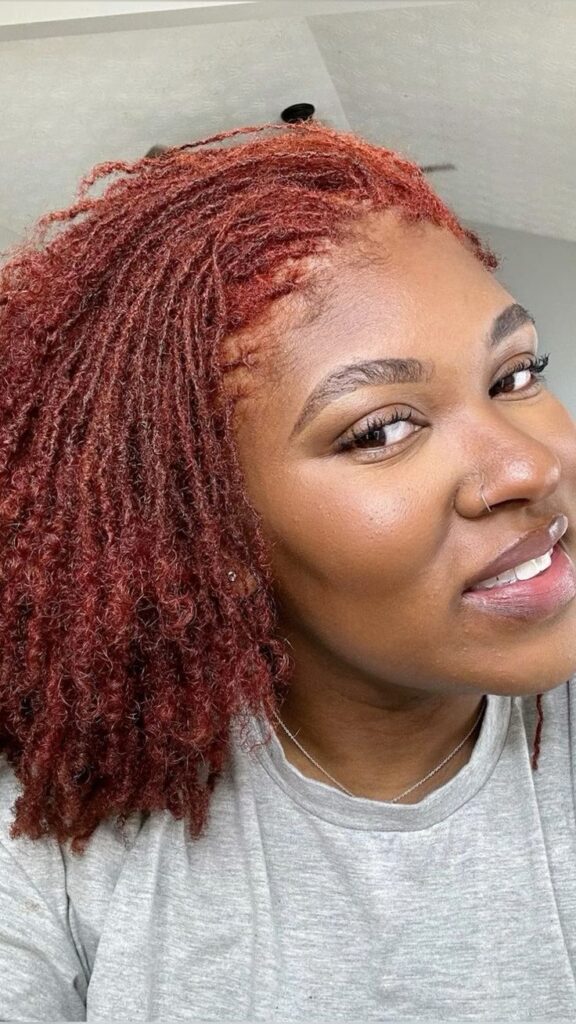 Woman on auburn colored sisterlocks