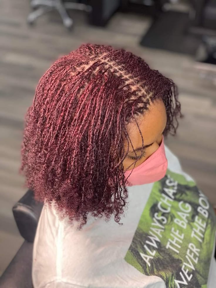 Woman on burgundy colored sisterlocks