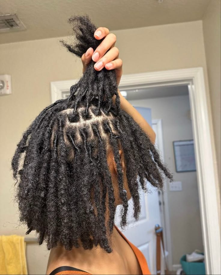 IMAGE OF A LADY CHECKING LOC LENGTH BY RAISING THEM UP