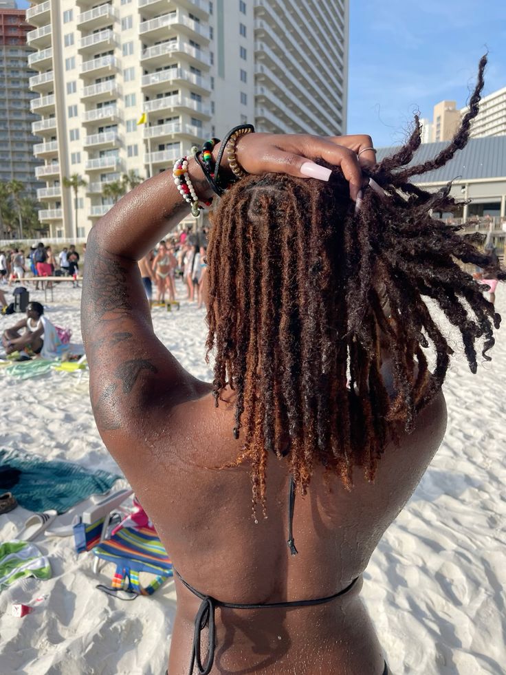 IMAGE OF A LADY ON A LONG BROWN LOCS AT THE BEACH 