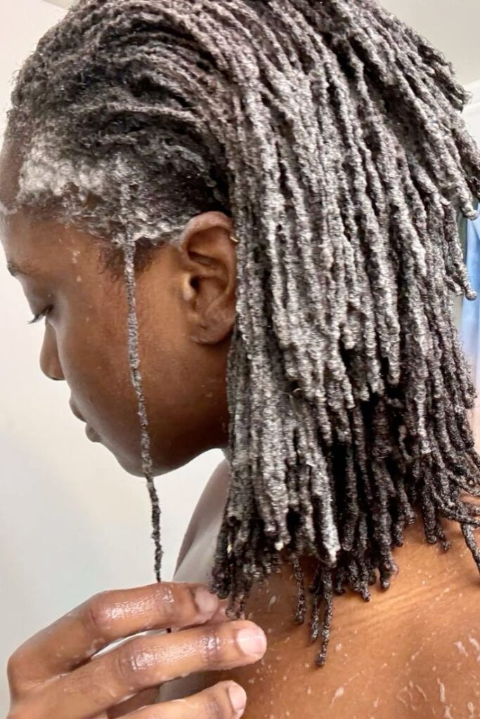 black girl with soapy locs deep cleaning