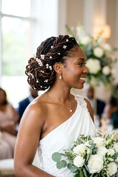 elegant bridal loc updo styled into a low textured loc bun with pearl accents.