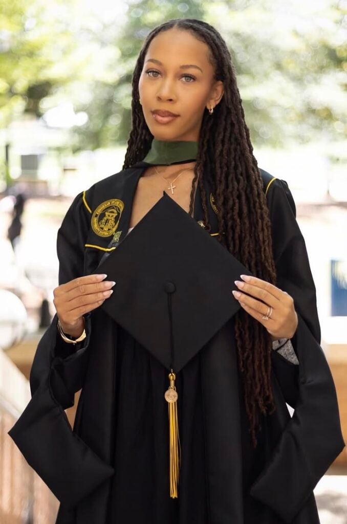 A GRDAUANT ON LOCS HOLDING HER GRADUATION CAP
