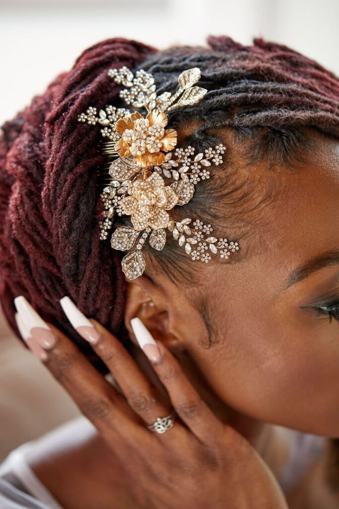 Side-Swept Burgundy Loc Bun with Floral Bridal Clip